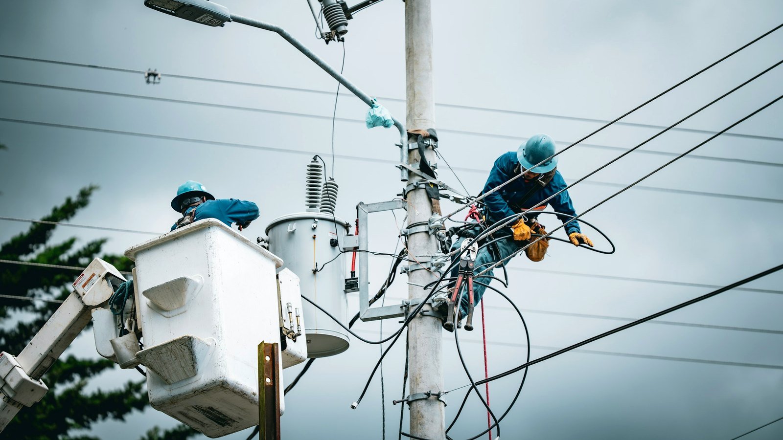 Linemen working on a utility pole and transformer
